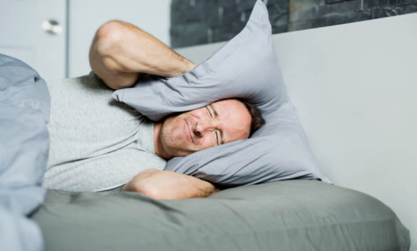 tinnitus man with pillow over ears